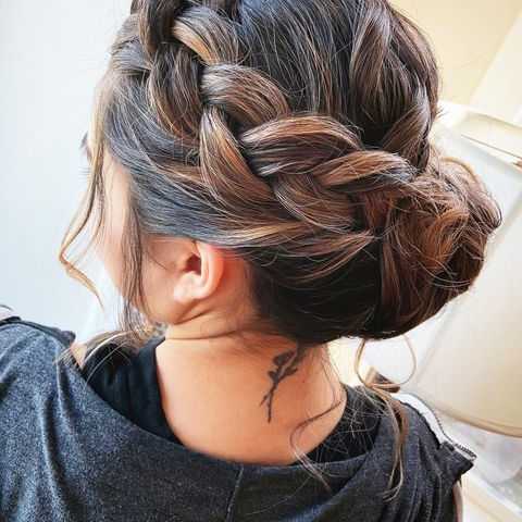 a braided updo with loose strands