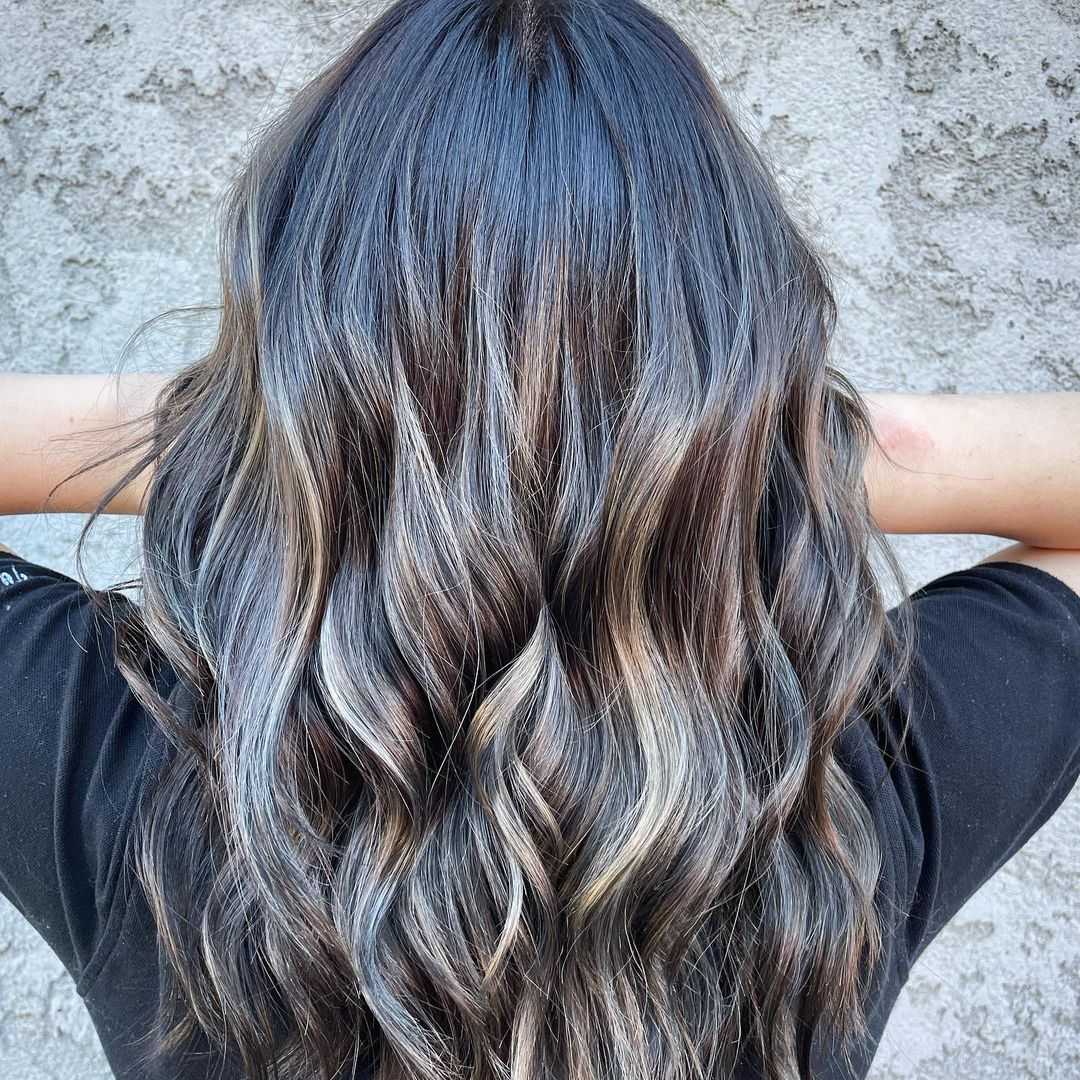 added subtle highlights to long brunette hair to create a stunning, timeless look